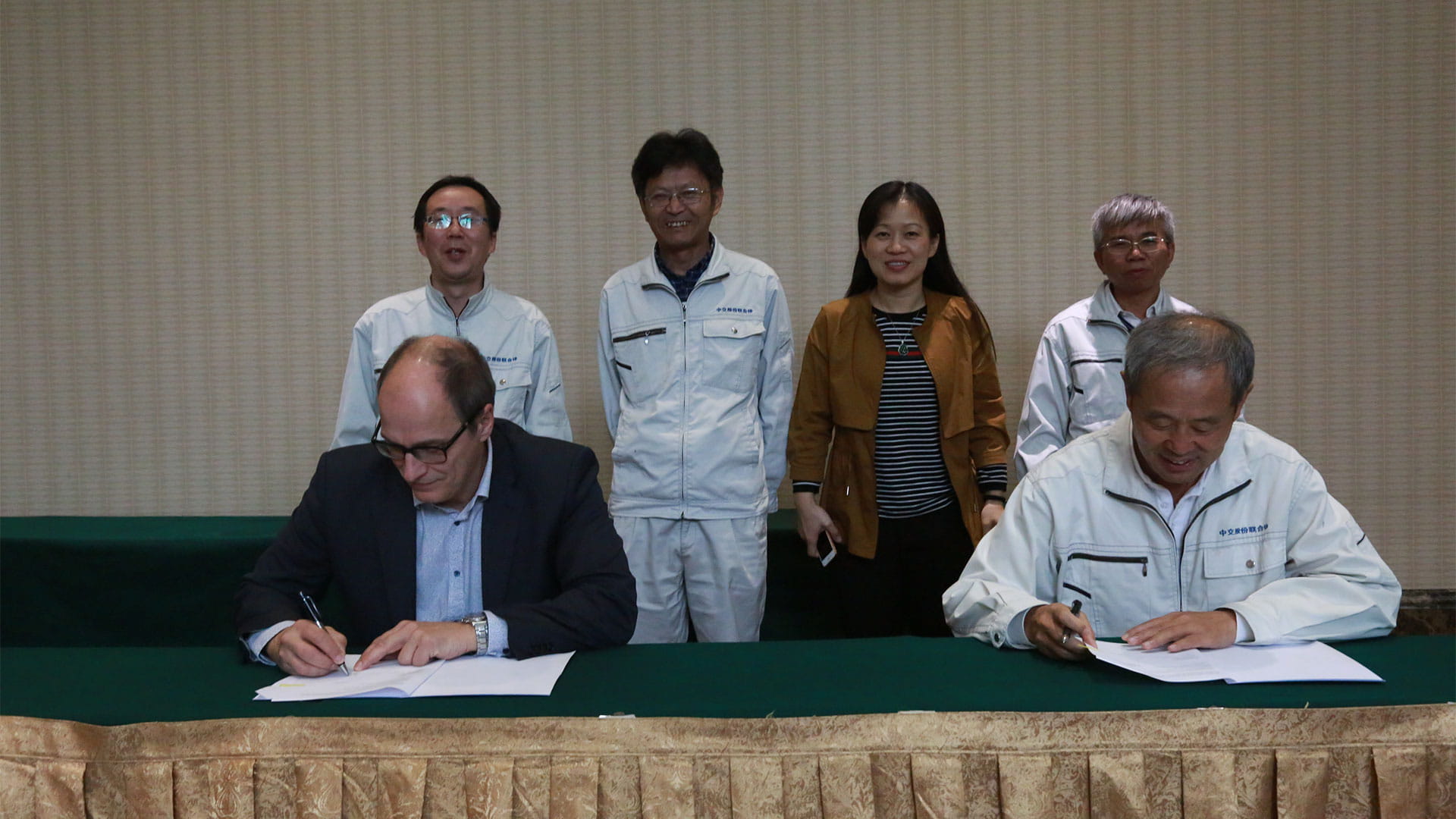 people sitting at table and signing documents